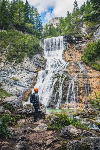 A man standing in front of a waterfall.